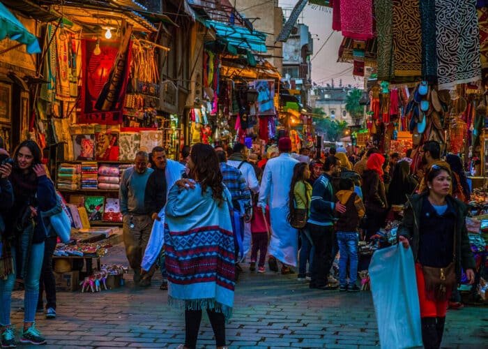 Vista nocturna de la Calle Al Muizz con arquitectura histórica y ambiente vibrante.