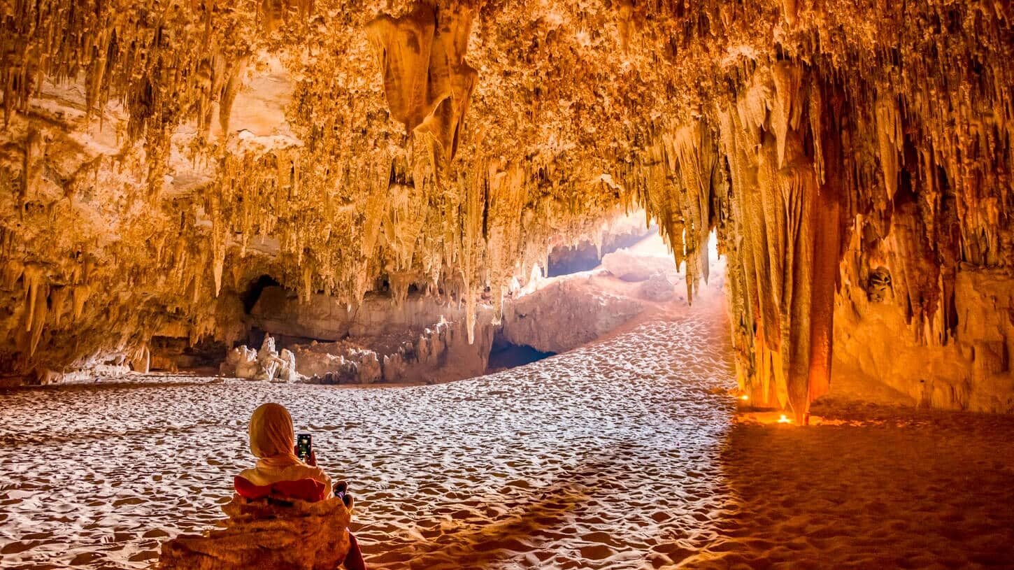 Niña sonriente dentro de la cueva Djara en el oasis de Bahariya.