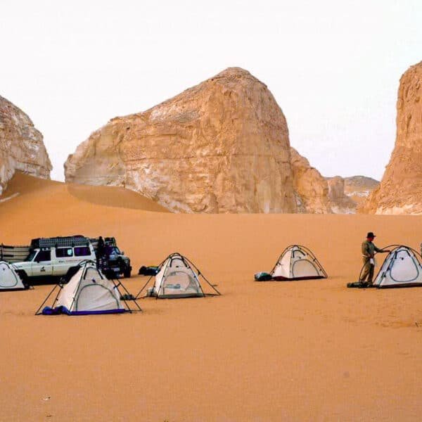 Camping en el Oasis de Bahariya con tiendas y paisaje desértico sereno.