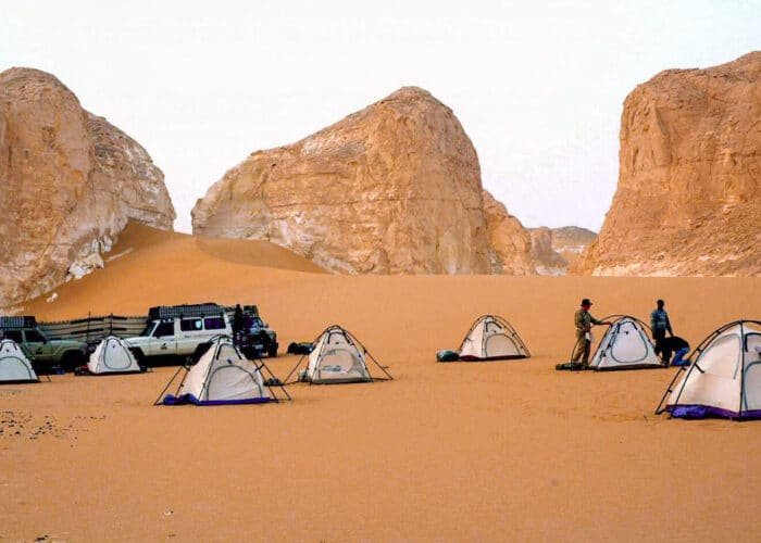 Camping en el Oasis de Bahariya con tiendas y paisaje desértico sereno.