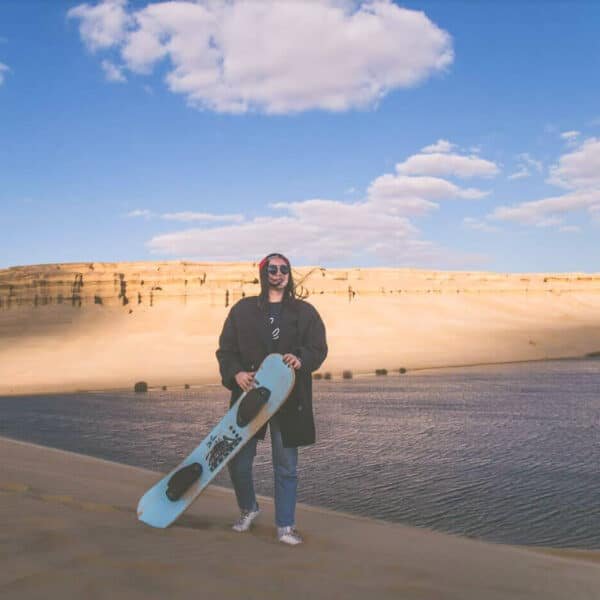 Niña practicando patinaje sobre arena en un entorno natural.
