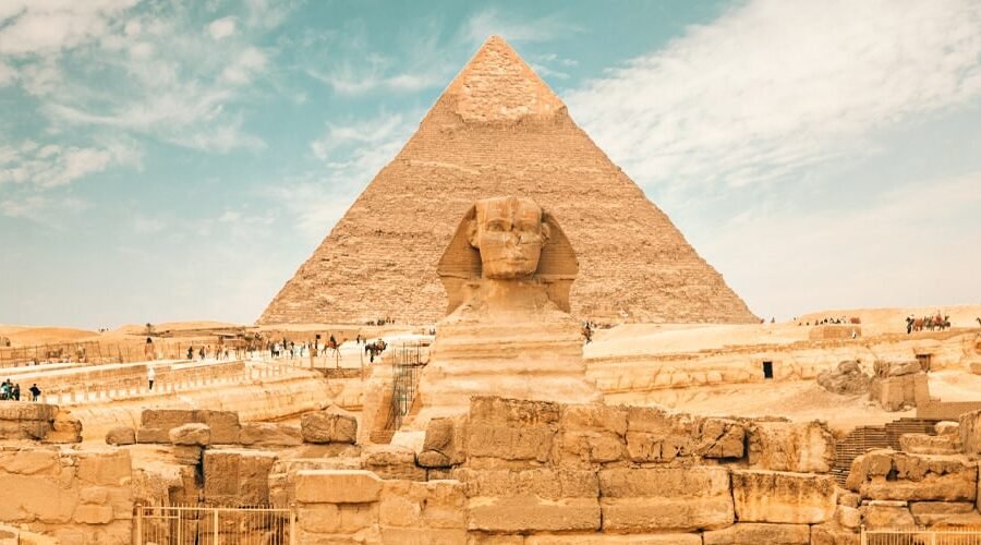 Esfinge gigante con las pirámides de Giza al fondo.
