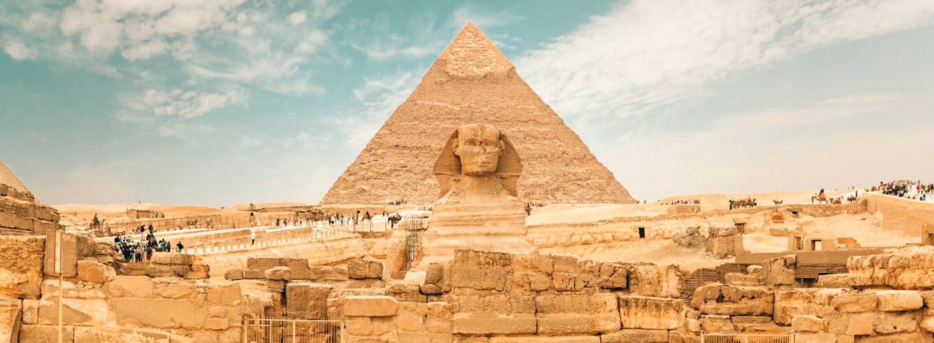 Esfinge gigante con las pirámides de Giza al fondo.