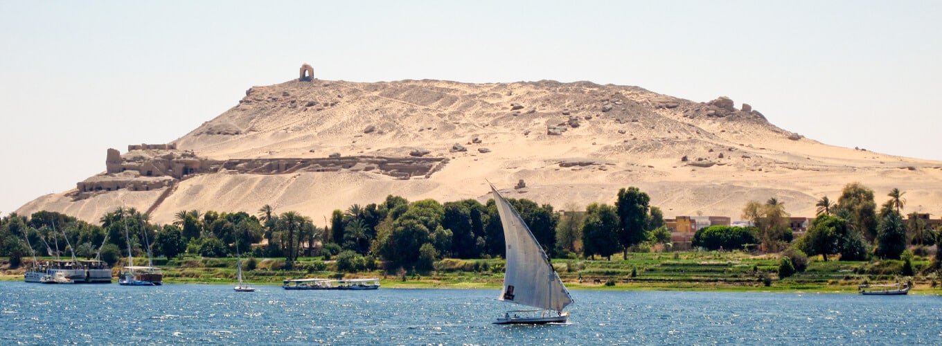 Vista impresionante de la Tumba de los Nobles en Asuán, Egipto, con arquitectura antigua intrincada.