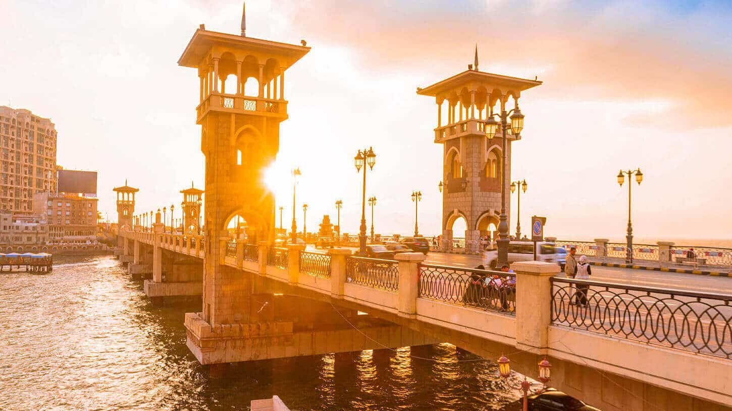 Puente Stanley en Alejandría al atardecer con colores vibrantes en el cielo.