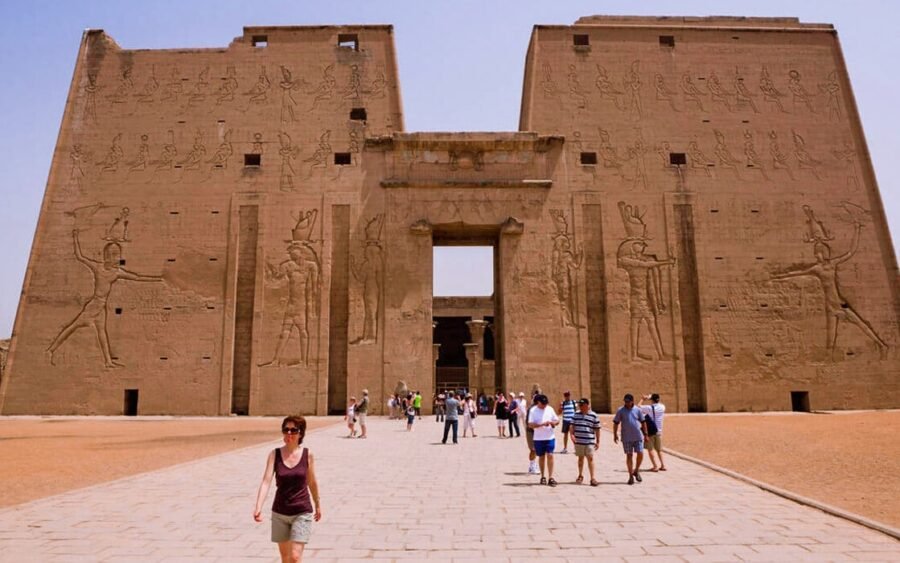 Turistas admirando la impresionante arquitectura del Templo de Edfu en Asuán.