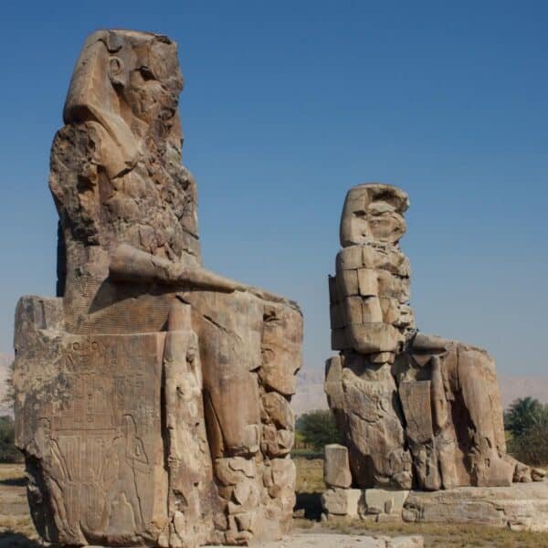 Estatuas de los Colosos de Memnón en Luxor, representando arte y arquitectura egipcia antigua.
