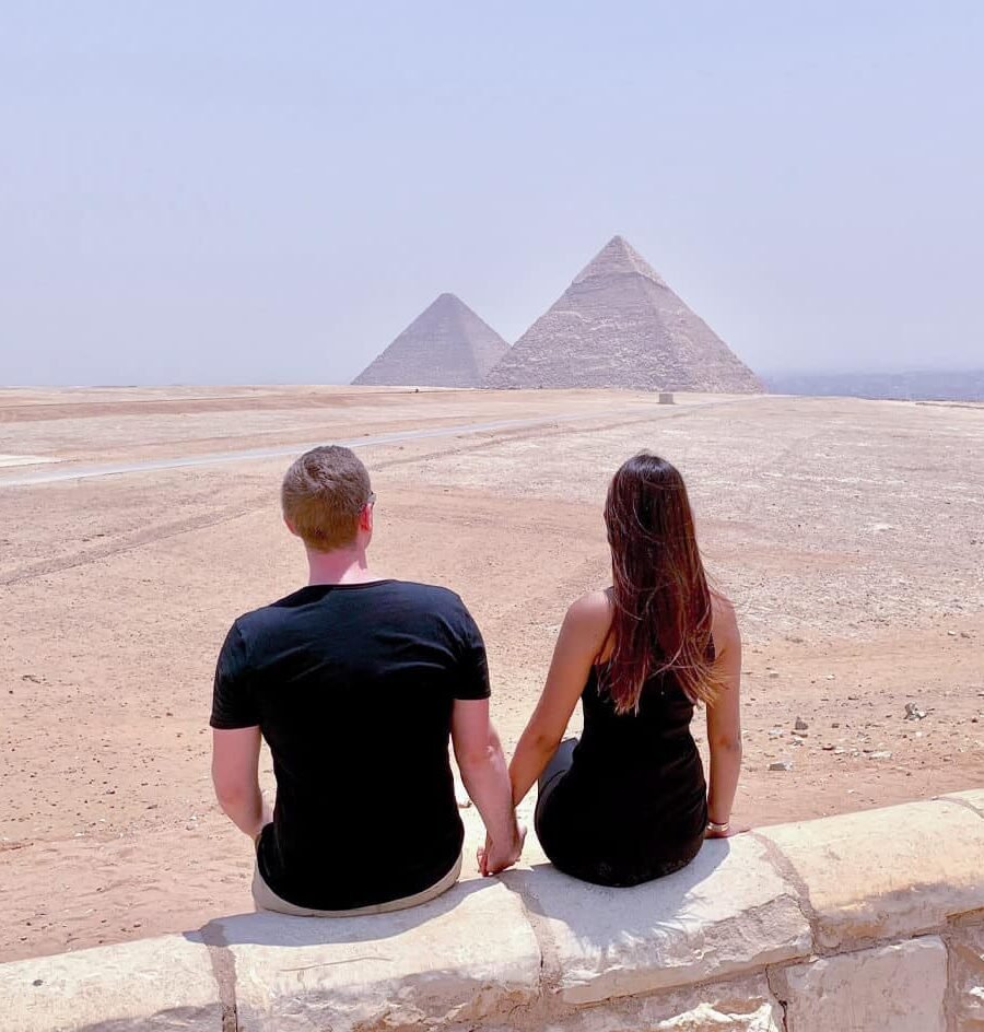 Pareja frente a las majestuosas pirámides de Giza en Egipto.