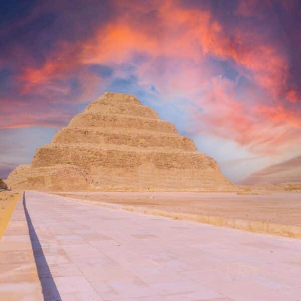 Pirámide escalonada al atardecer con colores vibrantes en el cielo.
