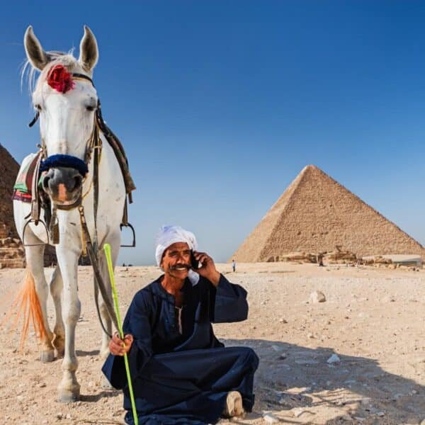 Hombre sentado frente a las pirámides de Egipto.
