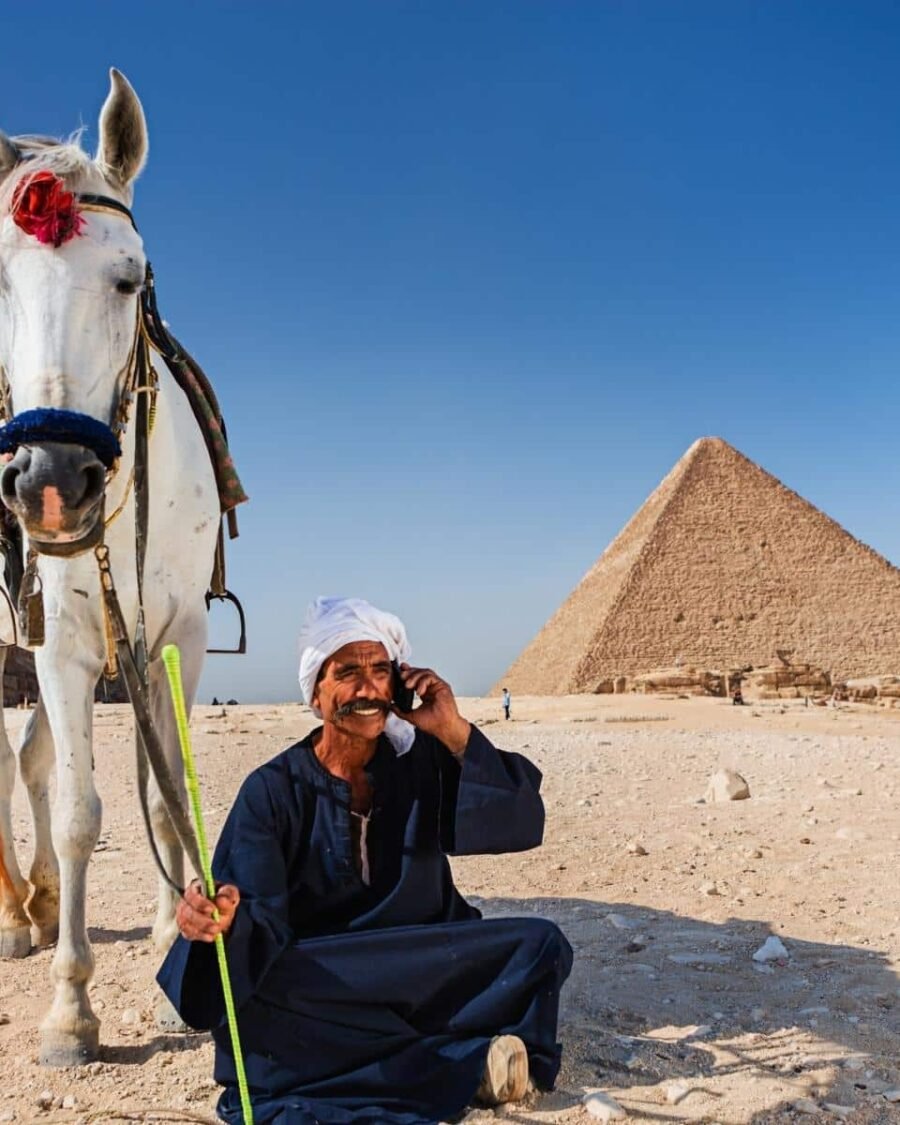Hombre sentado frente a las pirámides de Egipto.