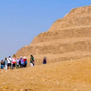 Turistas posando frente a la pirámide de Saqqara en Egipto.