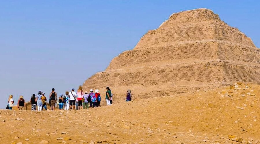 Turistas posando frente a la pirámide de Saqqara en Egipto.