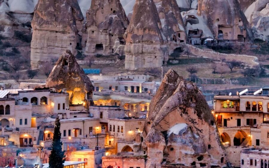 Vista nocturna de la ciudad de Goreme en Turquía con paisajes únicos y arquitectura iluminada.