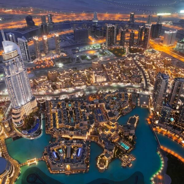 Vista aérea nocturna impresionante de Dubai con un horizonte vibrante y calles iluminadas.