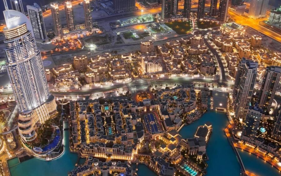 Vista aérea nocturna impresionante de Dubai con un horizonte vibrante y calles iluminadas.