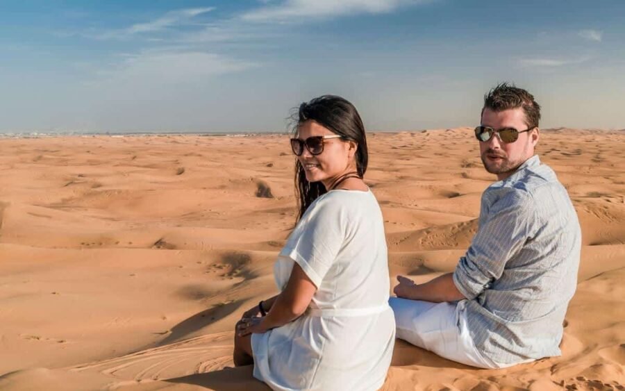 Pareja disfrutando de una emocionante aventura de safari en el desierto de Dubái.