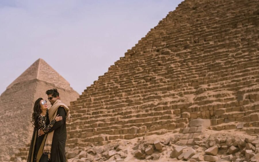 Pareja disfrutando de las pirámides de Giza mientras toman fotos especiales juntos.