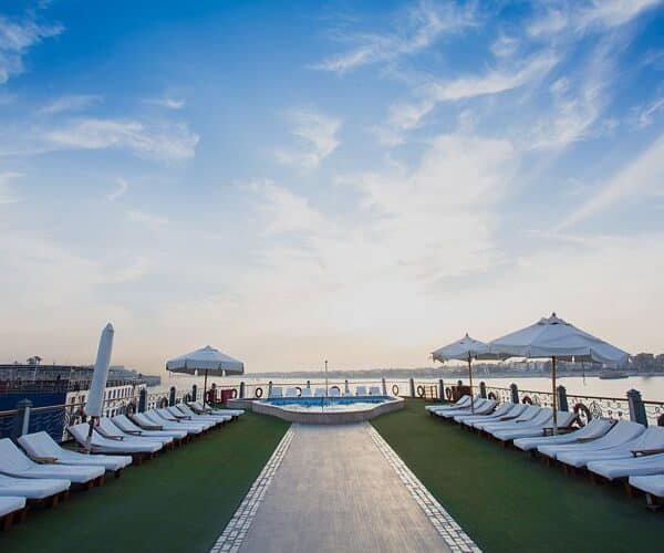 Princesa Sarah disfrutando de un crucero por el Nilo, rodeada de paisajes impresionantes.