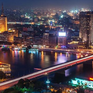 Vista nocturna de El Cairo con el horizonte iluminado y vibrante.