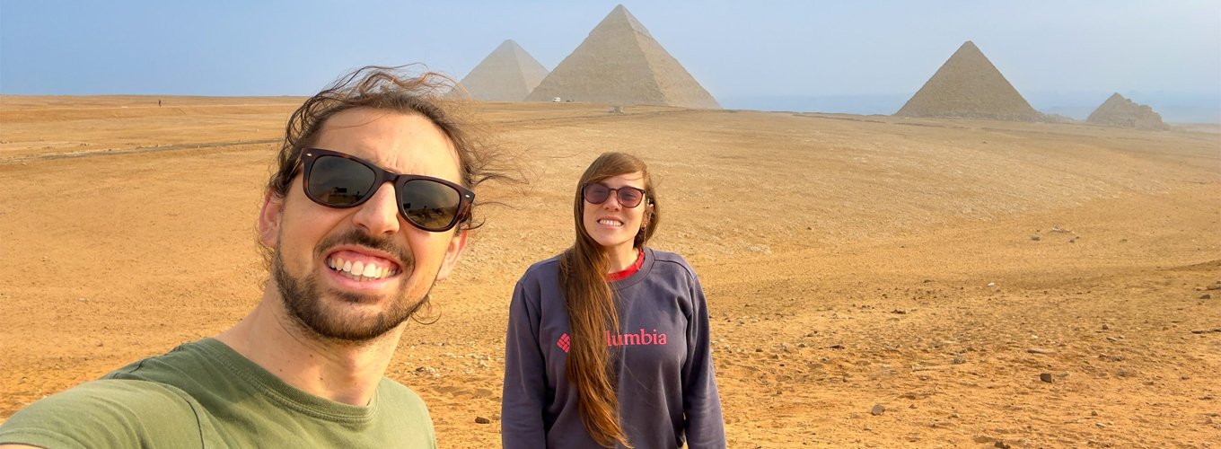 Un-turista-con-su-esposa-haciéndose-un-selfie-frente-a-las-pirámides Turista y su esposa toman un selfie frente a las pirámides de Egipto.